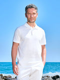 Man wearing an ivory polo and white trousers by the sea
