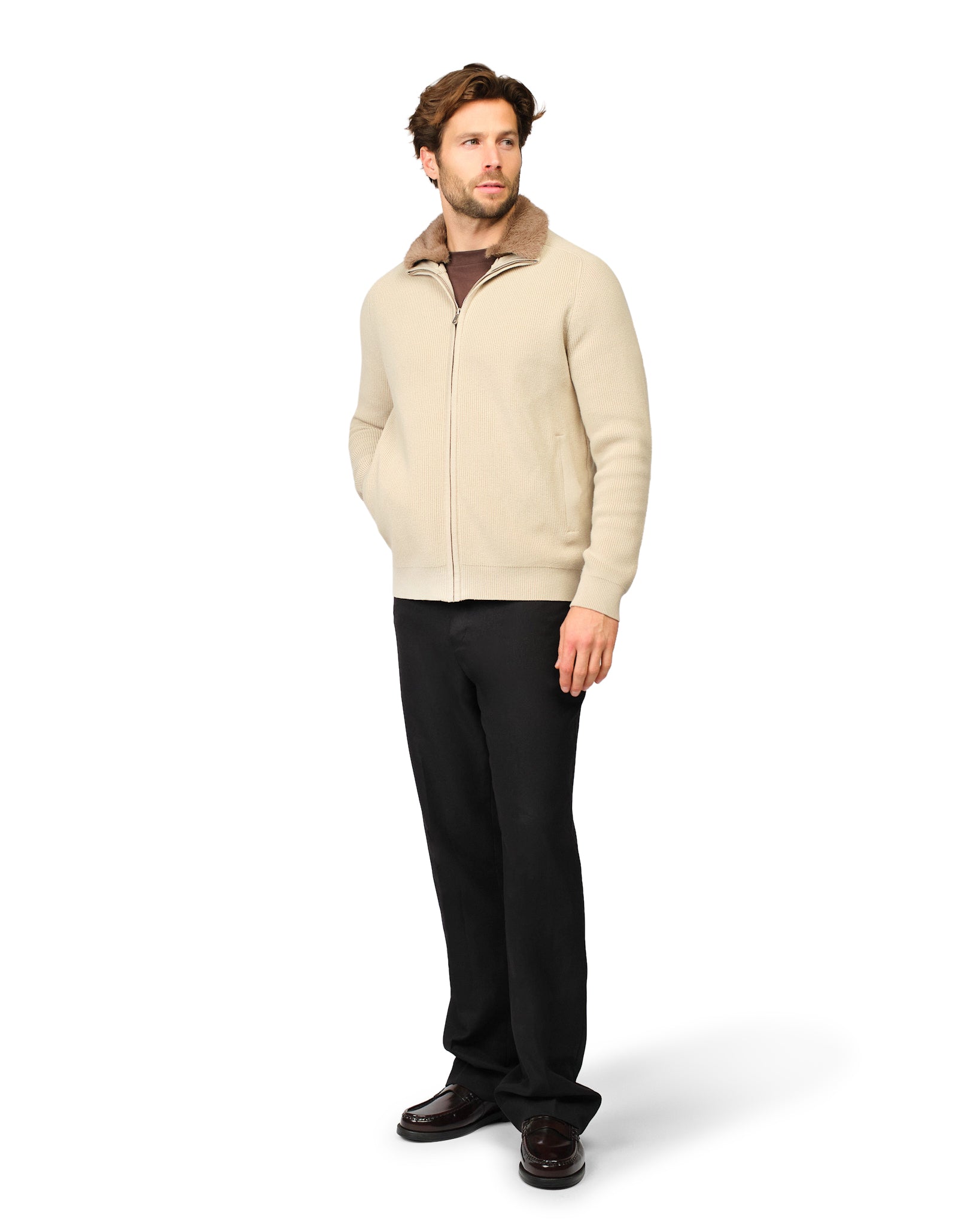 Man wearing a patterned shirt and black pants on a white background