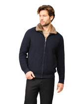 Man wearing a navy blue jacket with a fur-lined hood on a white background