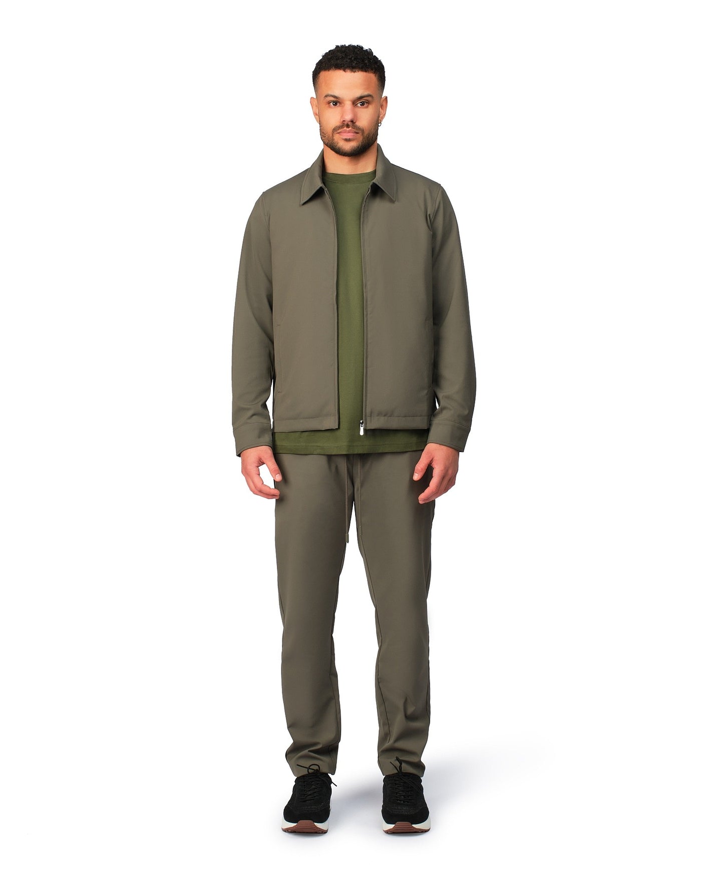 Green tech jacket with sleek design and zip closure, angled product view showing fit and details.
