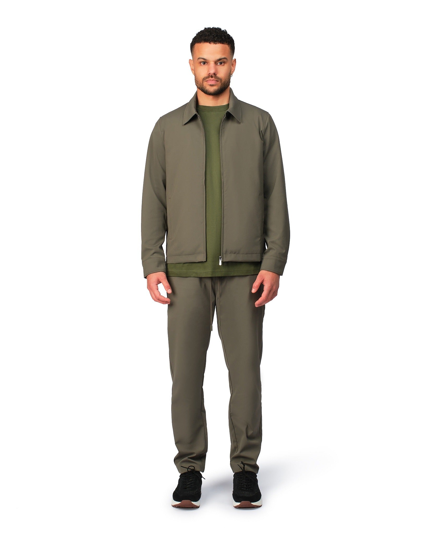 Green tech jacket with sleek design and zip closure, angled product view showing fit and details.
