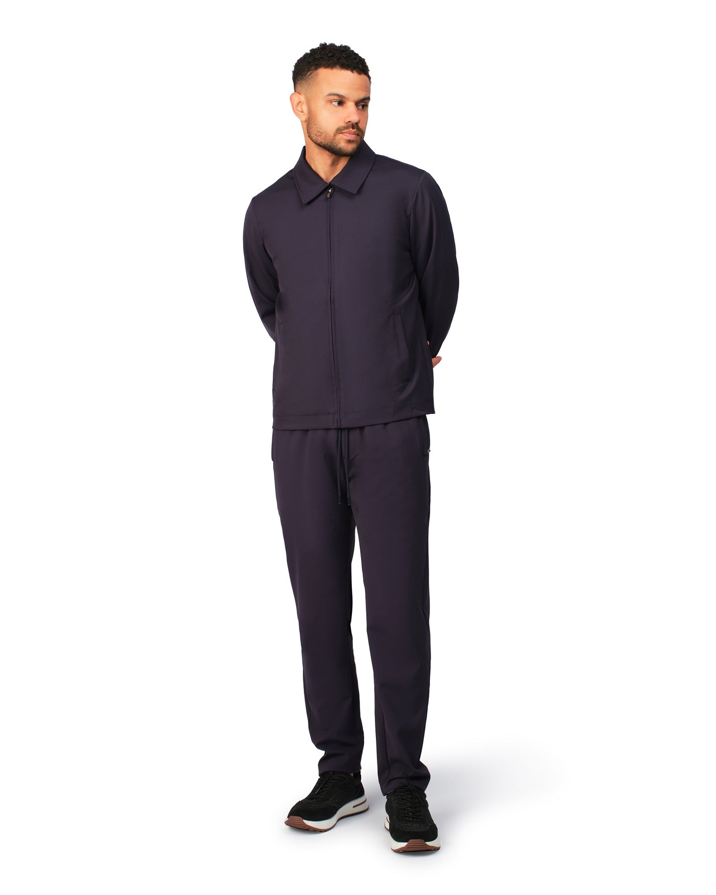 Man wearing a dark purple outfit on a white background