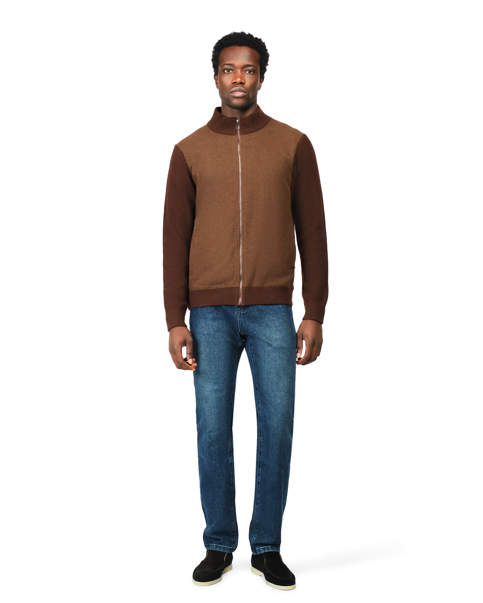 Man wearing a brown jacket and blue jeans on a white background