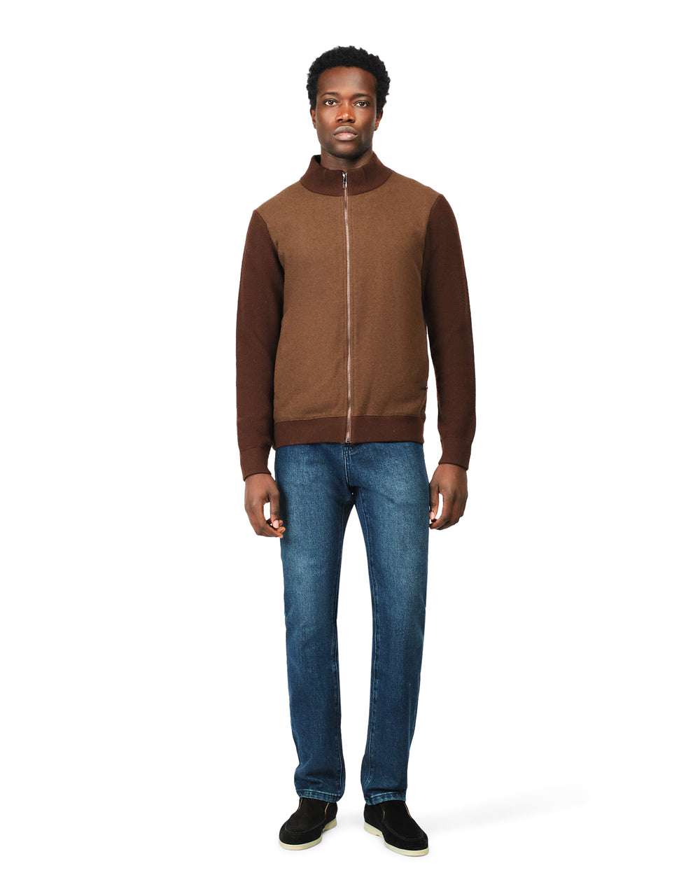 Man wearing a brown jacket and blue jeans on a white background