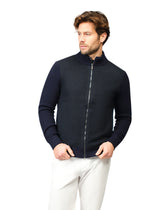 Man wearing a navy blue zip-up sweater over a white shirt on a white background