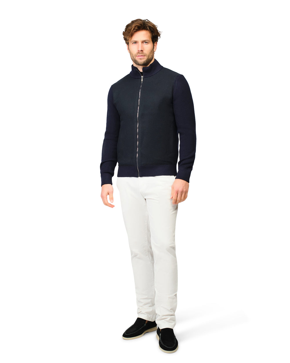Man wearing a navy blue jacket and white pants on a white background