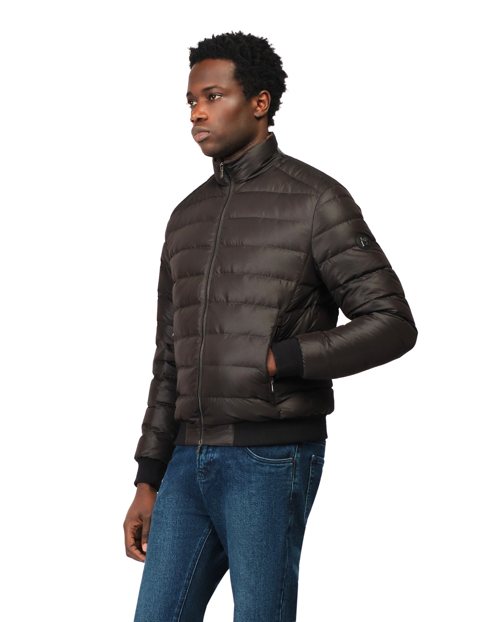 Man wearing a brown puffer jacket and blue jeans on a white background