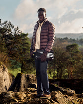 Man standing on a rocky outcrop with a scenic background