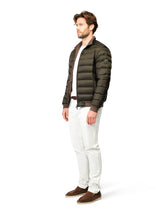 Man wearing a green puffer jacket with a white background