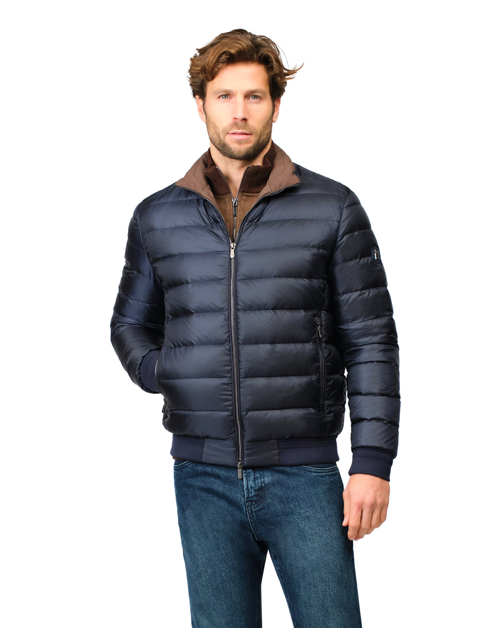 Man wearing a navy blue puffer jacket with a brown collar on a white background