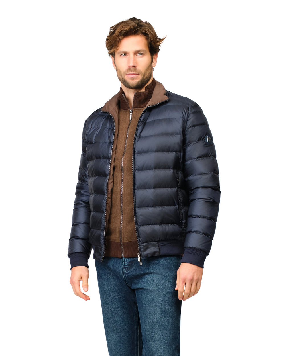 Man wearing a navy blue puffer jacket over a brown shirt on a white background