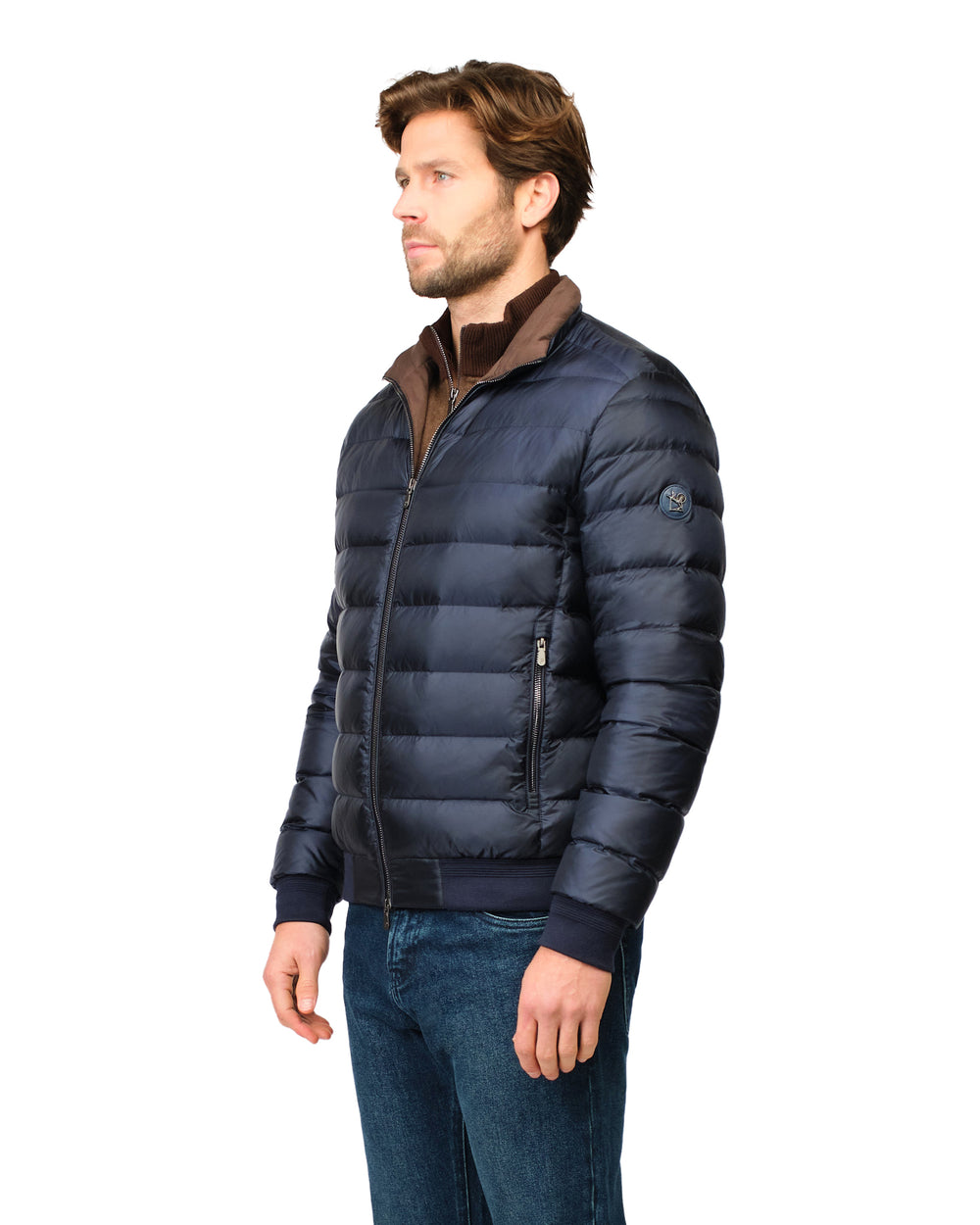 Man wearing a navy blue puffer jacket with a brown collar on a white background