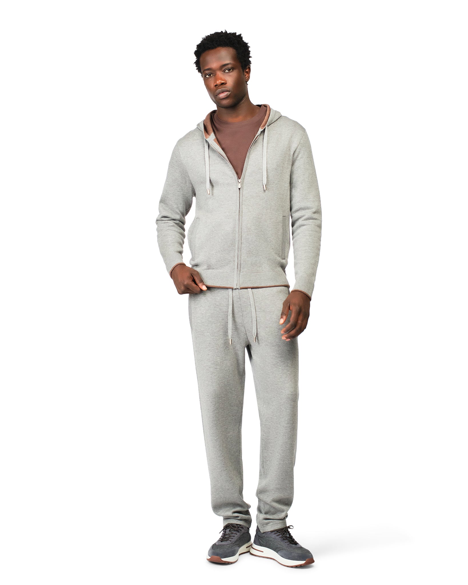 Man wearing a gray tracksuit on a white background