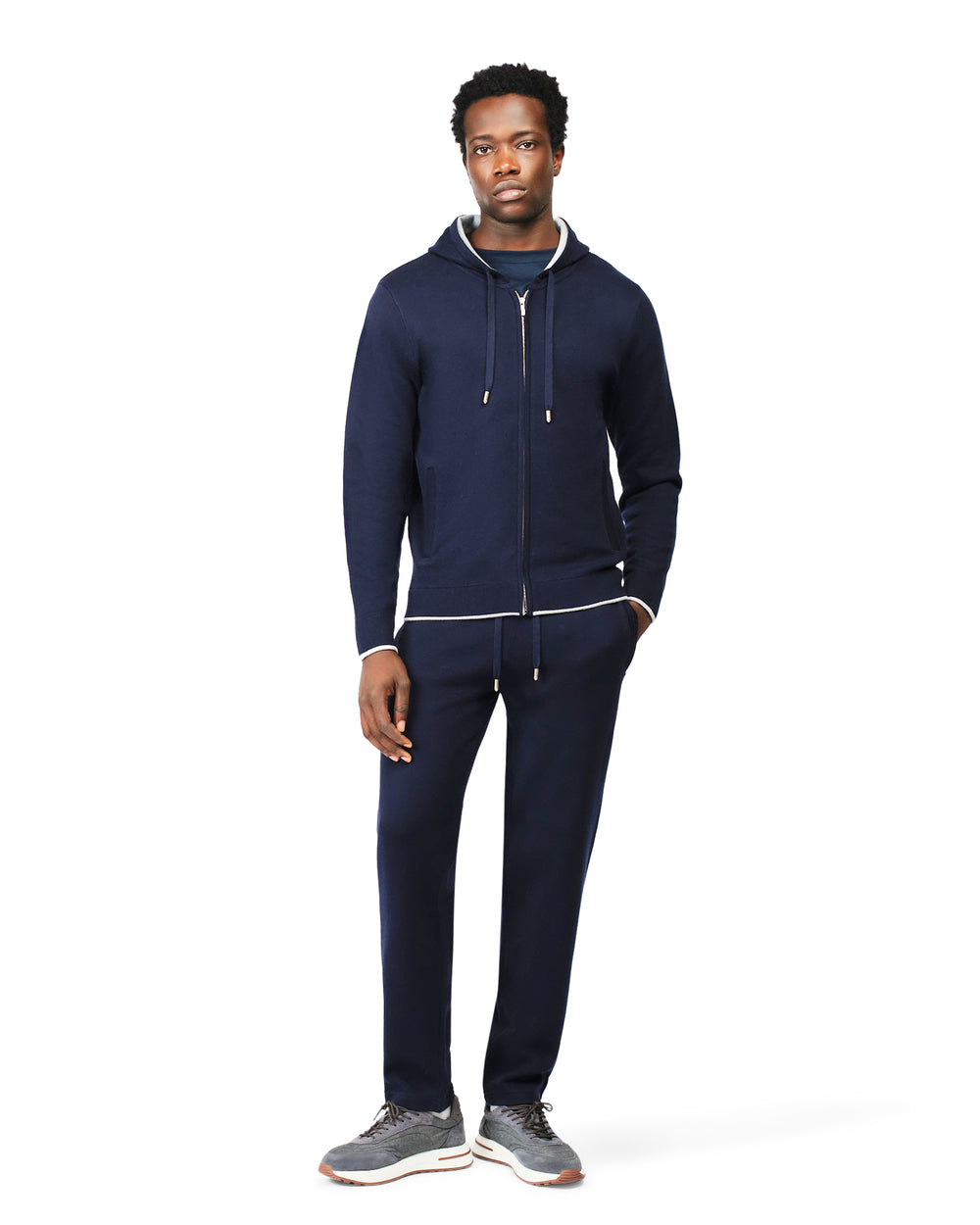 Man wearing a navy tracksuit on a white background