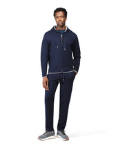 Man wearing a navy tracksuit on a white background